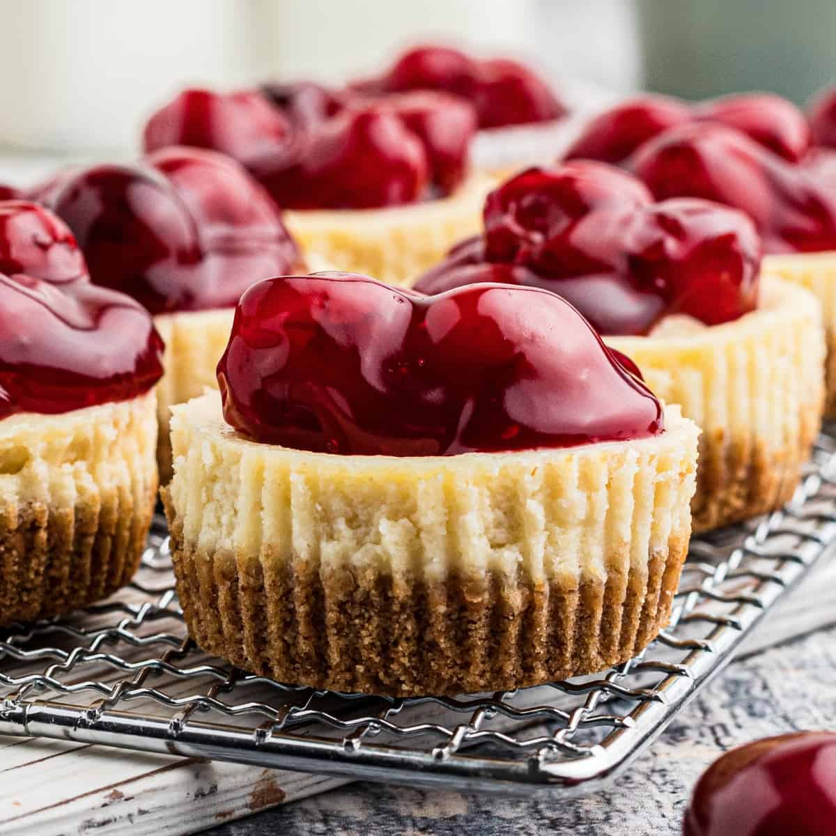 Close up of mini cheesecakes topped with cherry pie fillings.