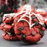 Stacked of red velvet cookies with spider and spider web decorations.