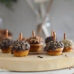 Pumpkin Muffins with sprinkles and pretzel sticks on top.