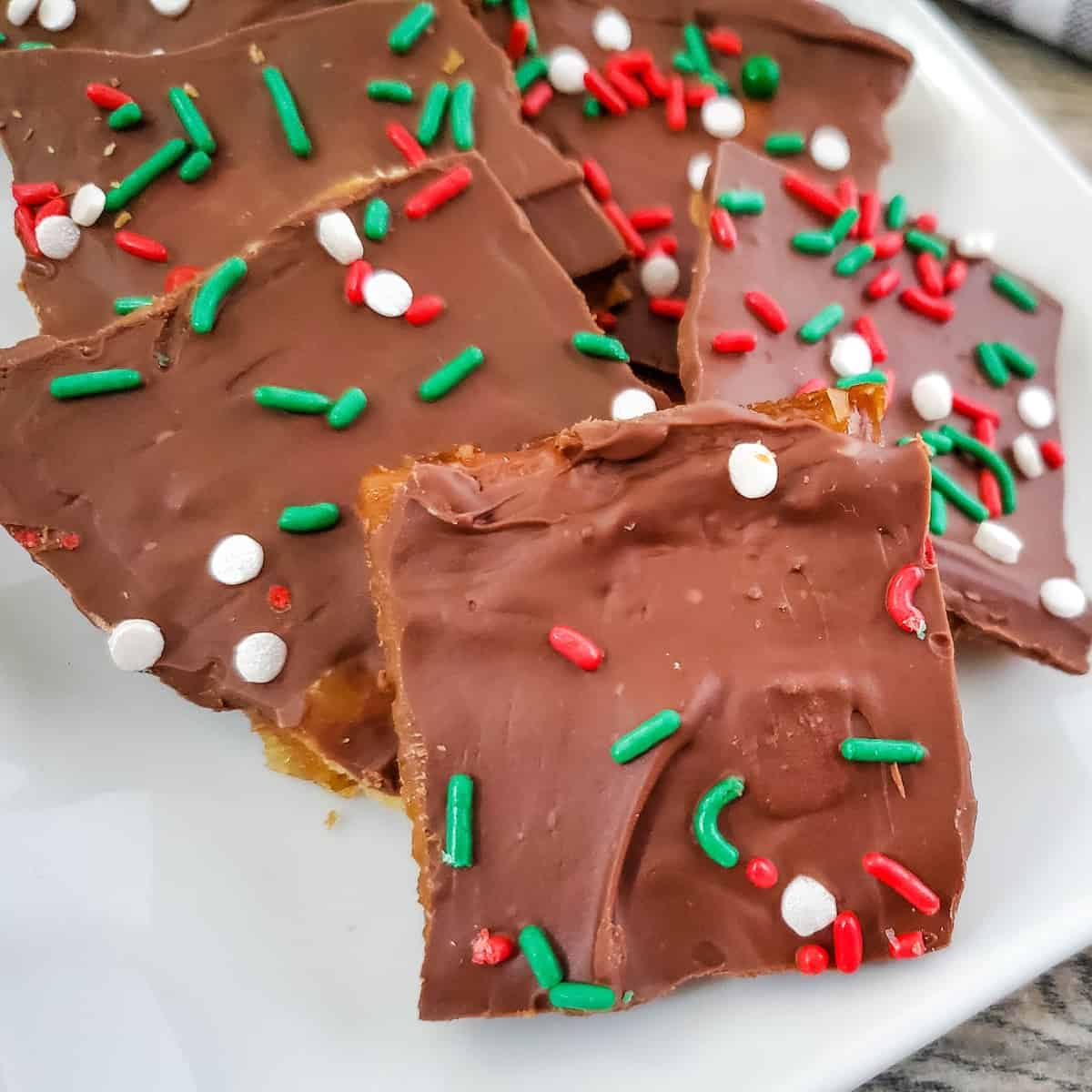 Cracker Candy with green, white, and red sprinkles on a white plate.