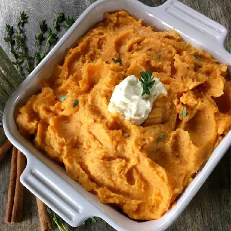 Mashed sweet potato in a white casserole.