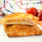 Stack of homemade ham and cheese hot pockets on a white table.