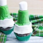 Chocolate cupcakes topped with green, candy coated ice cream cones and marshmallows to look like elf hats.