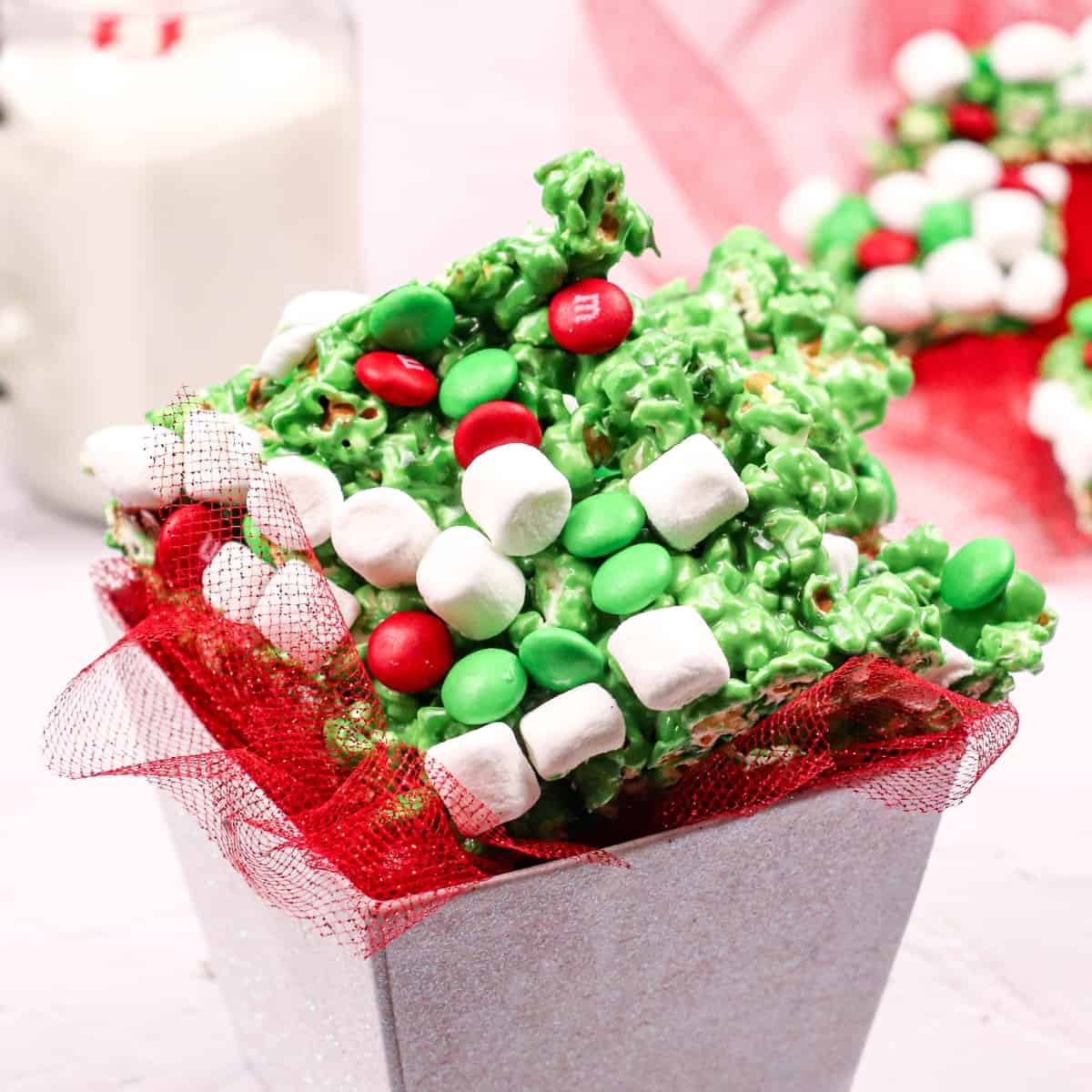Box of green popcorn with marshmallows and green and red M&Ms.