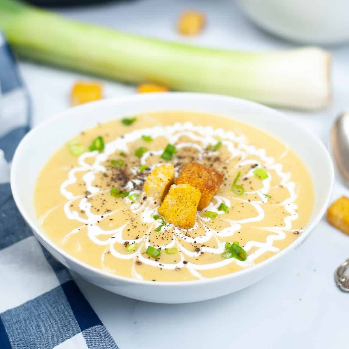 White bowl of potato leek soup.