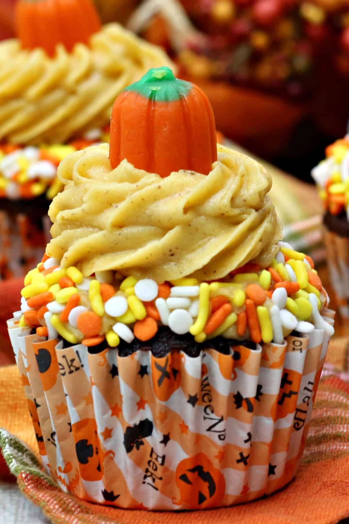 Closeup of a mocha chocolate cupcake with pumpkin spice frosting and sprinkles.
