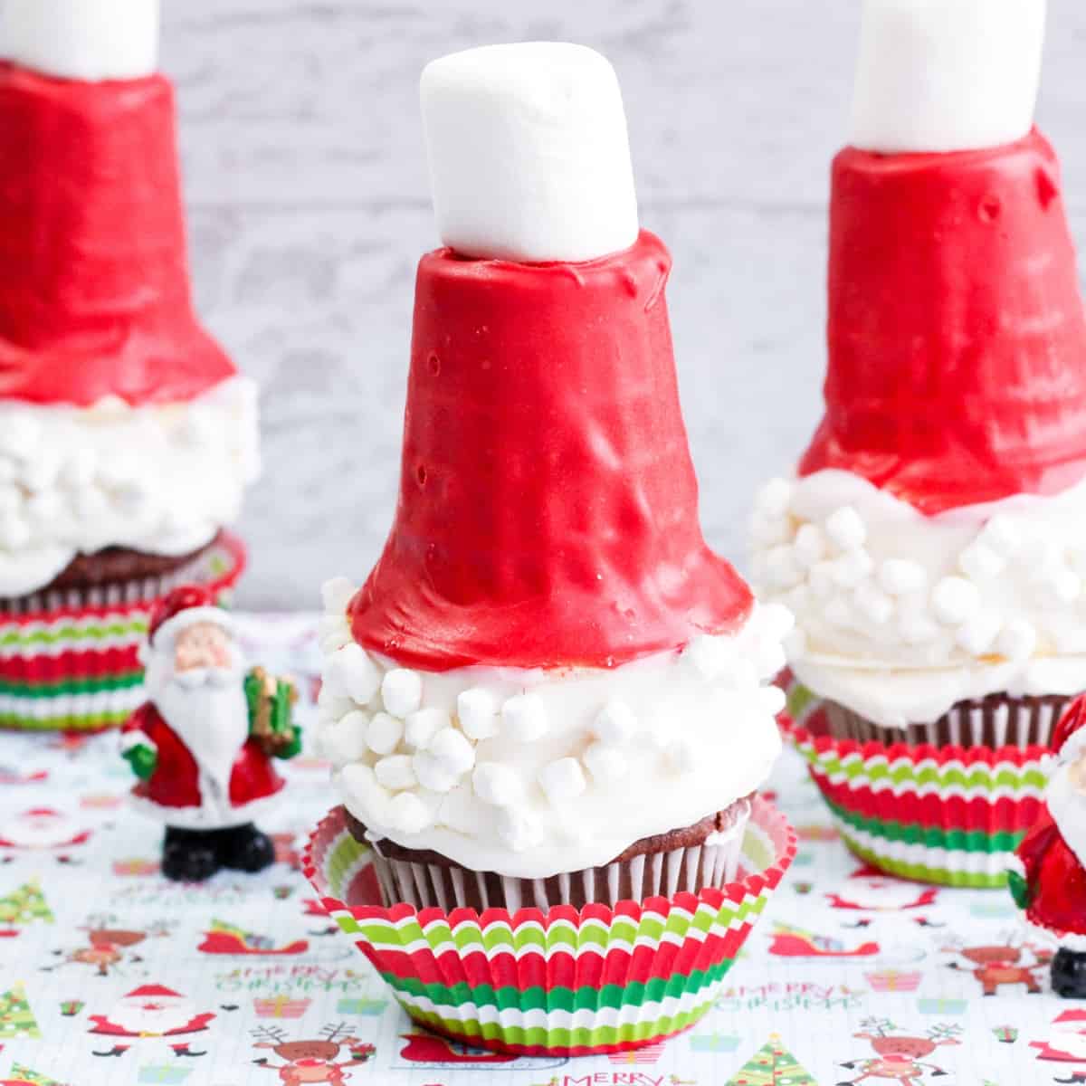 Chocolate cupcakes topped with candy-coated ice cream cones and marshmallows to look like a Santa Hat.