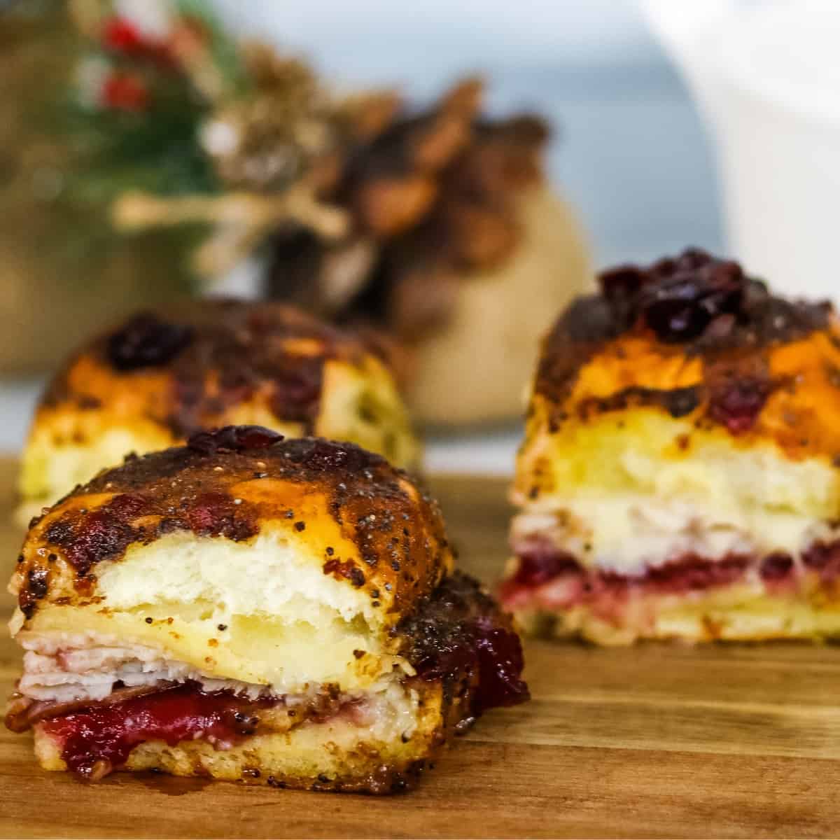 Sliders with turkey and cranberry on a wooden board.
