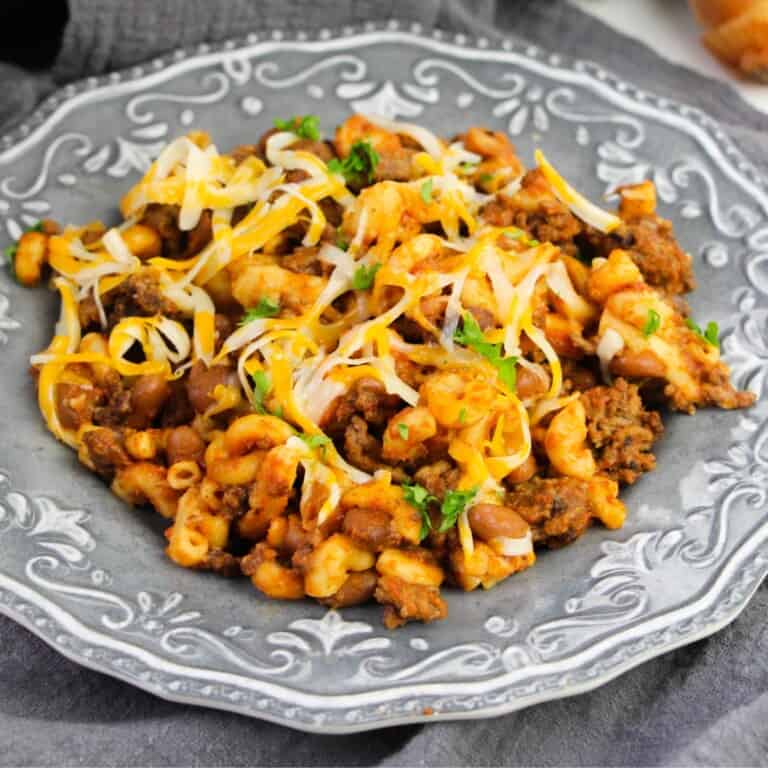 A plate of Chili Mac topped with shredded cheese.