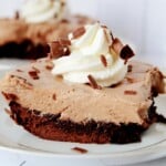 White plate of Chocolate Mousse with whipped cream on top.