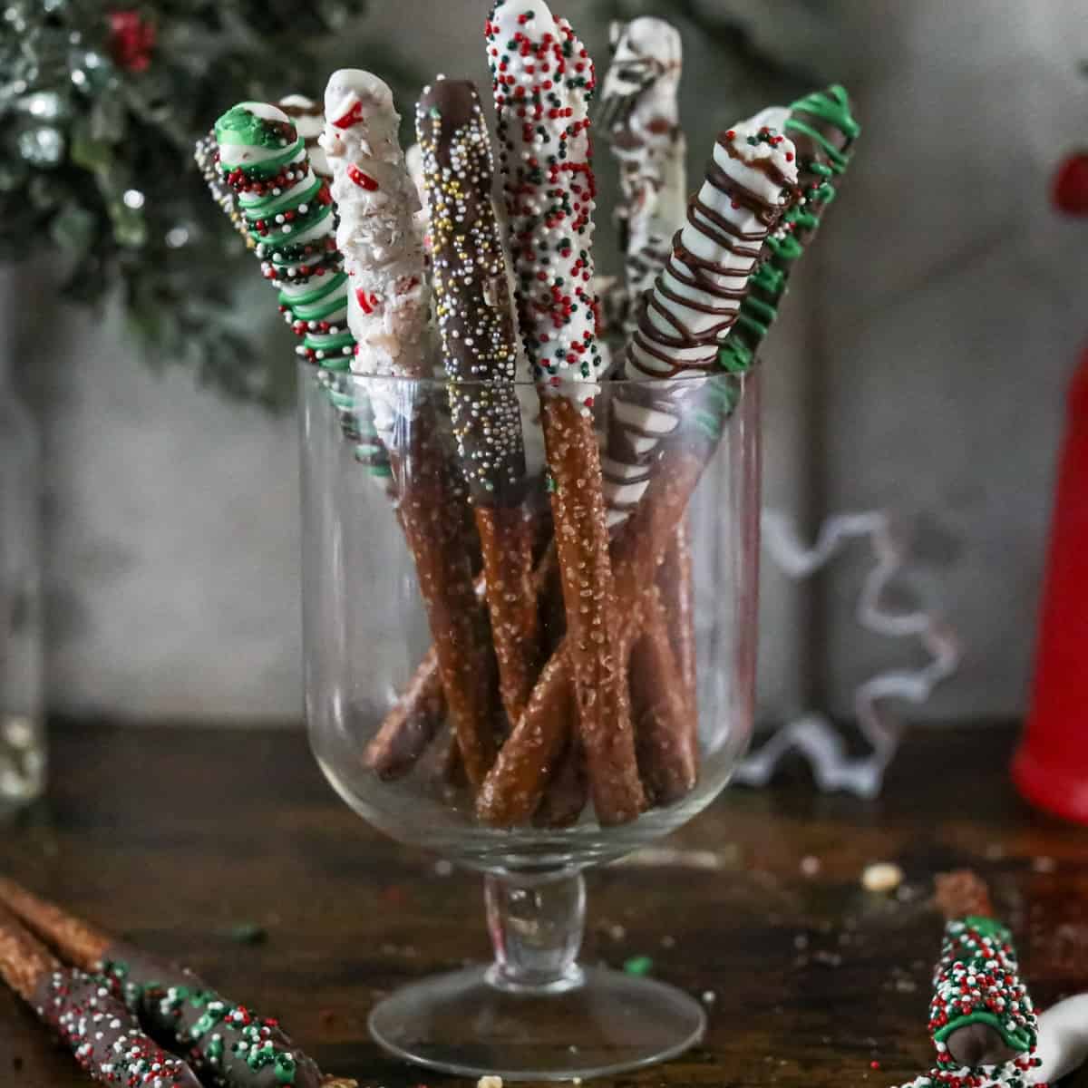 Chocolate and sprinkles dipped pretzel rods in a glass dish.