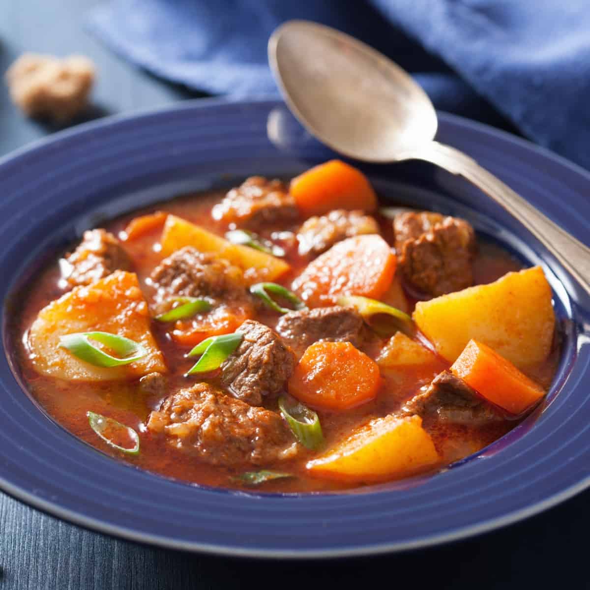 Classic Beef Stew on a blue plate on the table.