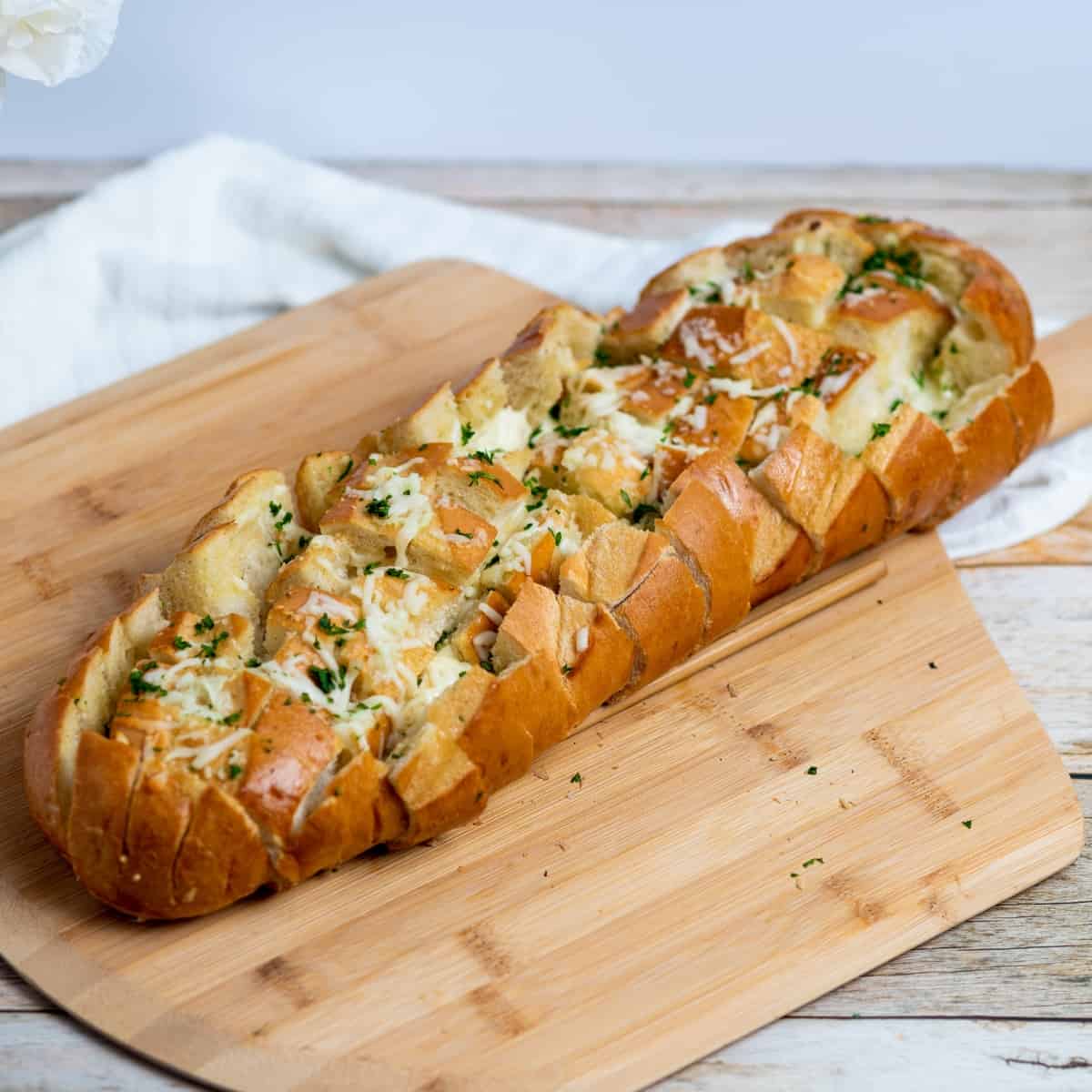 Sliced Garlic Cheesy Bread on a wooden board.