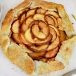 Peach Galette sitting on a parchment paper.