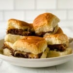 Cheeseburger sliders stacked on a plate.