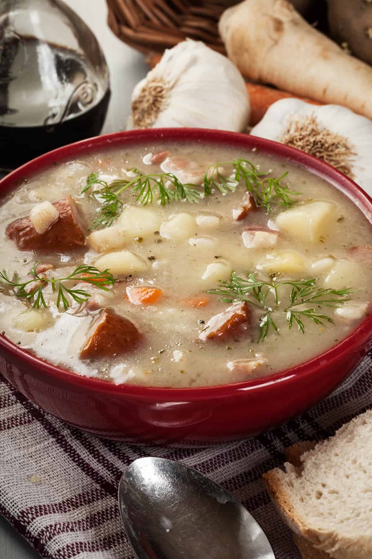 A red bowl of sausage potato soup.