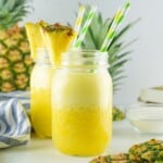 Close up of Pineapple drink in a mason glass garnished with pineapple wedge.