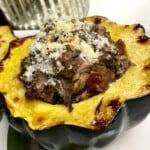 Mushroom stuffed acorn squash on a plate.