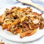 Close up shot of roasted yum topped with chopped pecans.