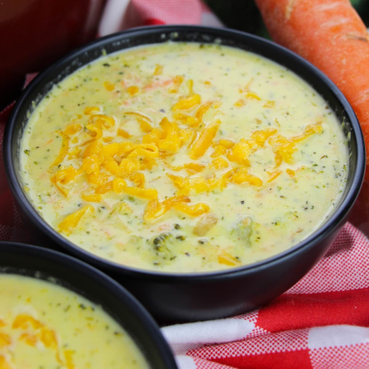 Bowl of Broccoli Cheddar Soup topped with shredded cheese.