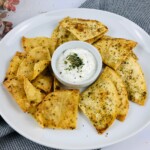 Bowl of white dip surrounded by Baked Tortilla Chips.
