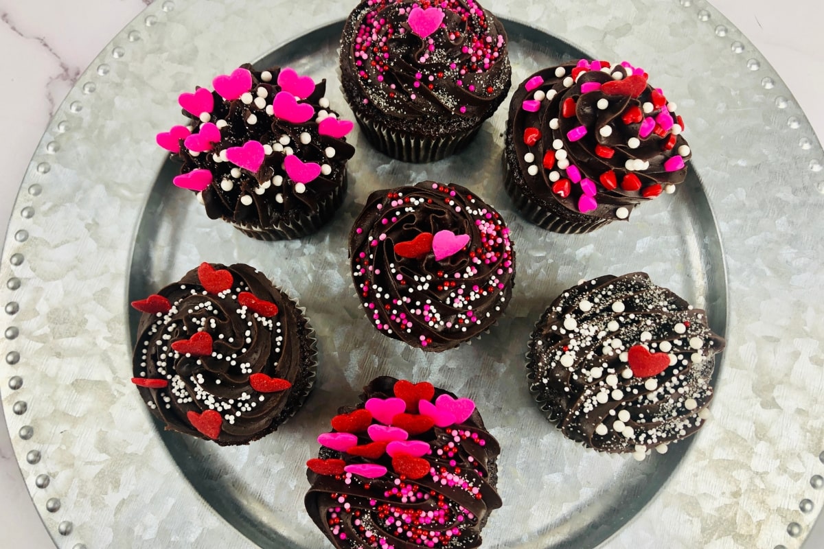 Chocolate Cupcakes filled with raspberry jam sitting on a silver plate.
