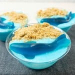 Vanilla yogurt topped with crushed graham crackers and shark gummies.
