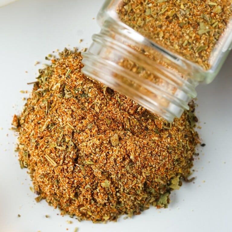 Jar spilling seasoning mixture onto a white countertop.
