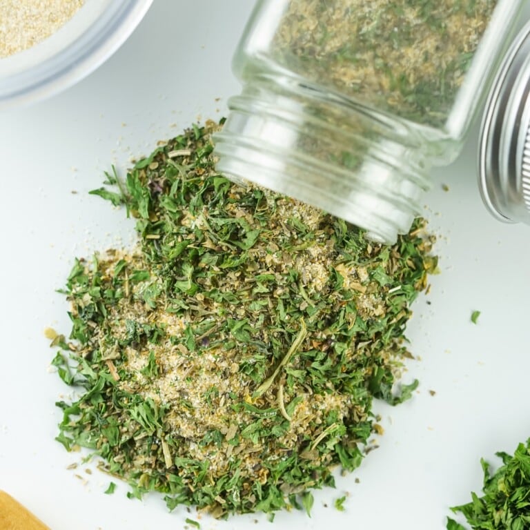 Jar spilling Spice Blend onto a white countertop.