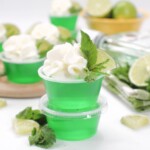 Two stacked plastic cups of mojito Jello shots.