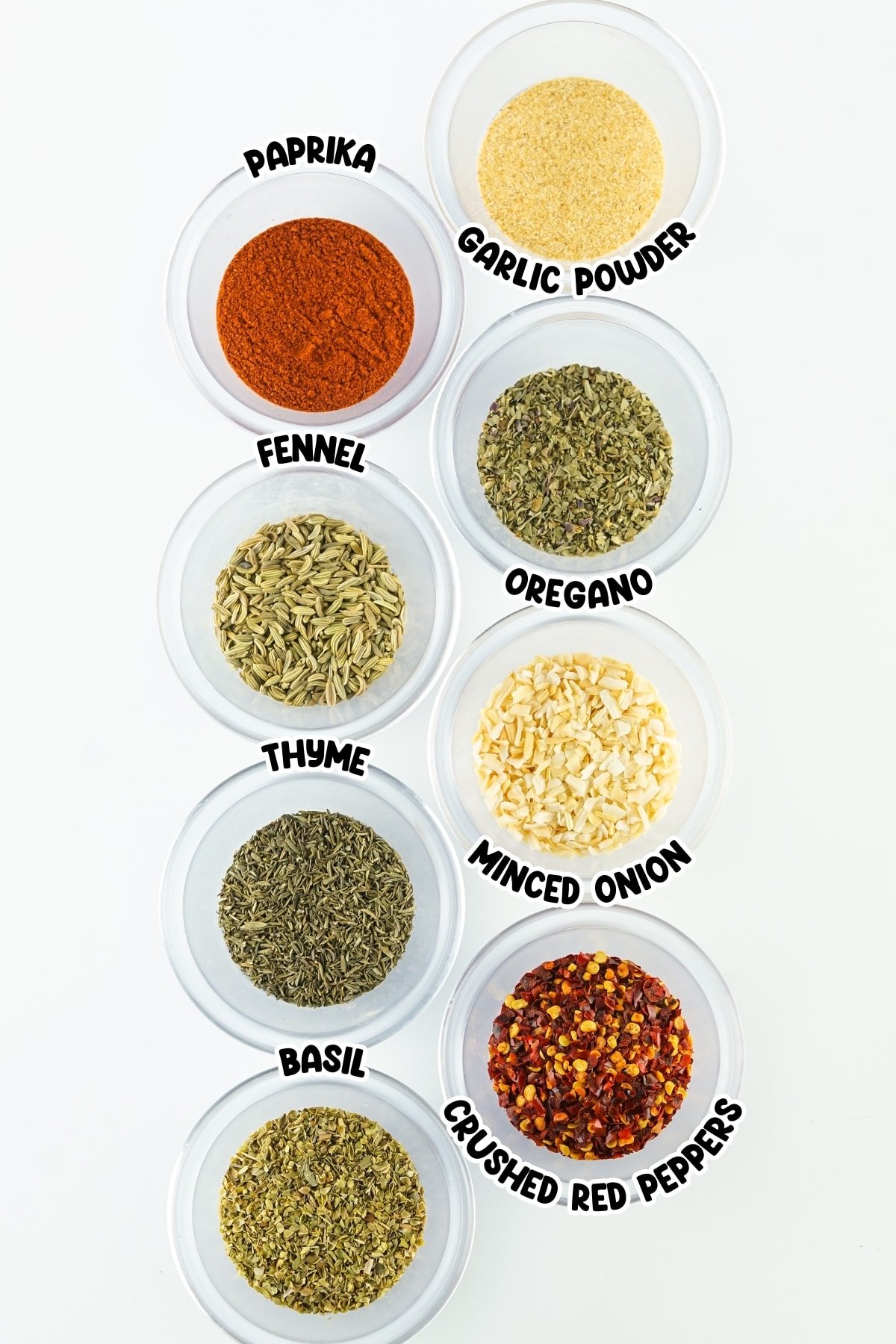 Ingredienst for pizza seasoning sitting on a white countertop.