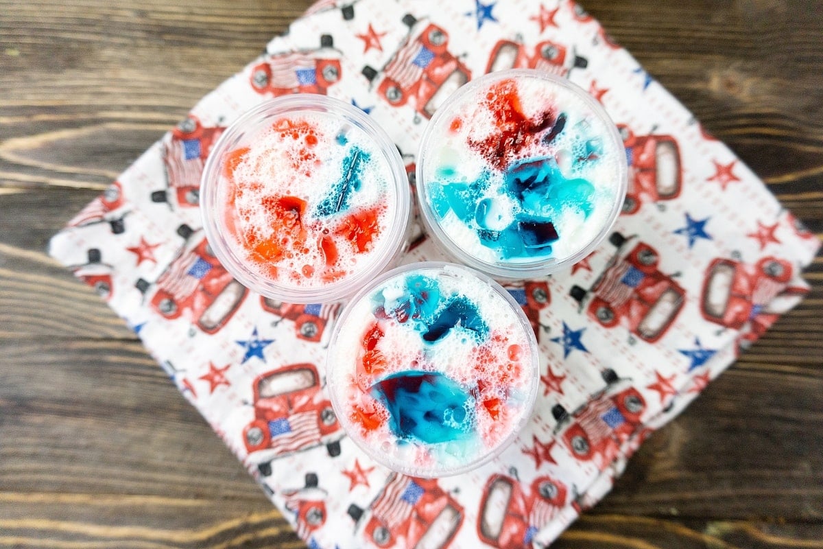 Red, white, and blue jello shots in a small plastic container.