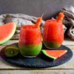 Glasses of layered Kiwi Watermelon Slushies.