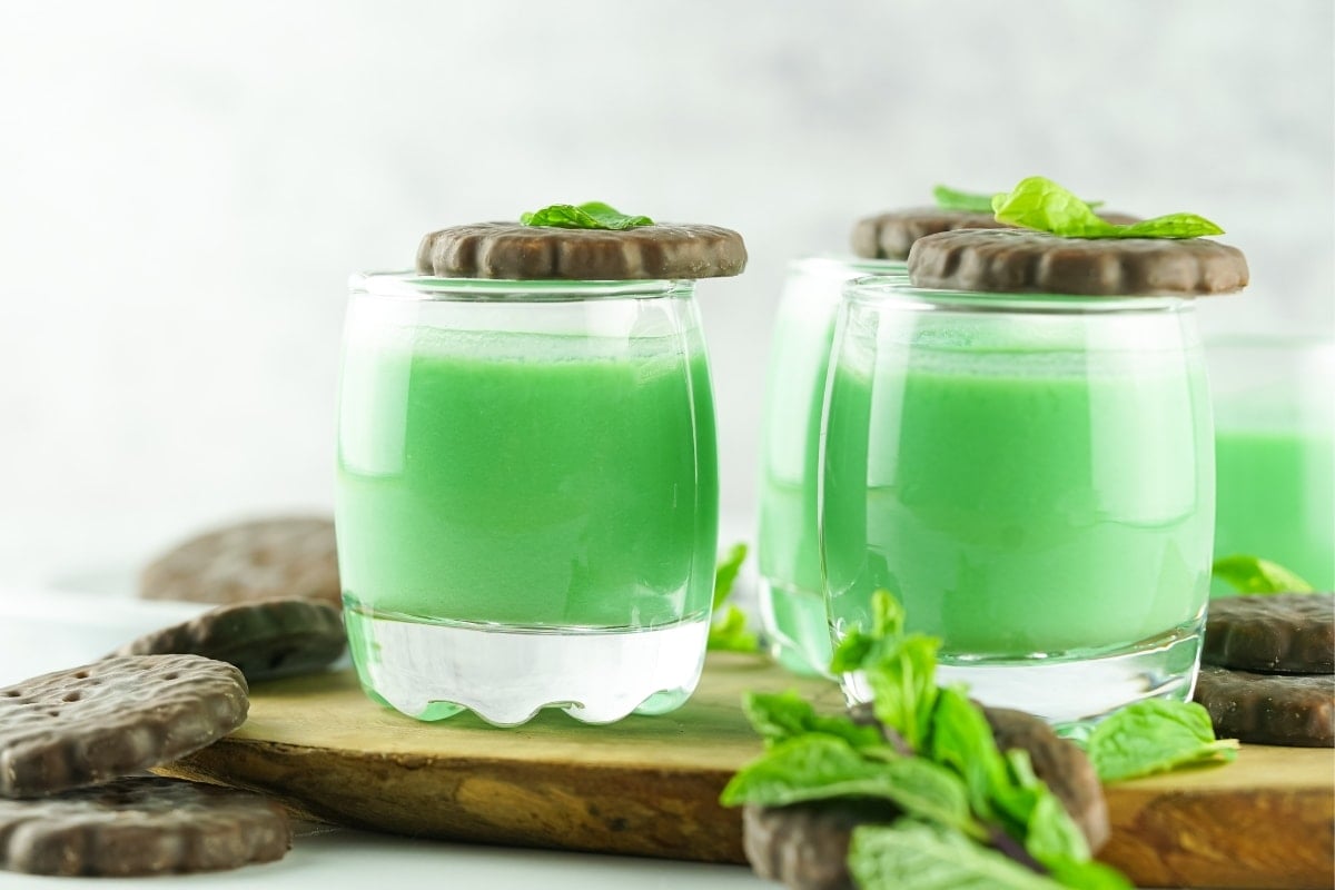 Several Dirty Girl Scout Shots garnished with mint chocolate cookies and fresh mint.
