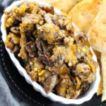 White, oblong bowl of eggplant salsa dip.