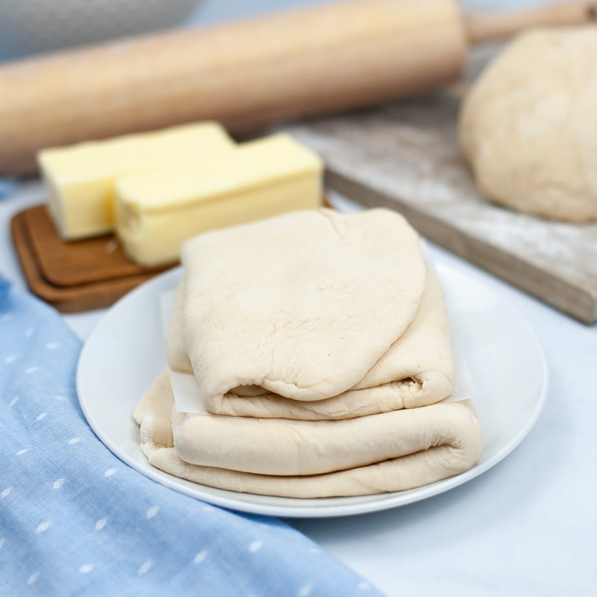 Small, white plate with folded Puff Pastry Dough.