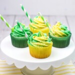 Four 7up soda cupcakes sitting on a cake stand.