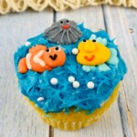 Beach Cupcakes with blue frosting and adorable fish and sea creature decorations.
