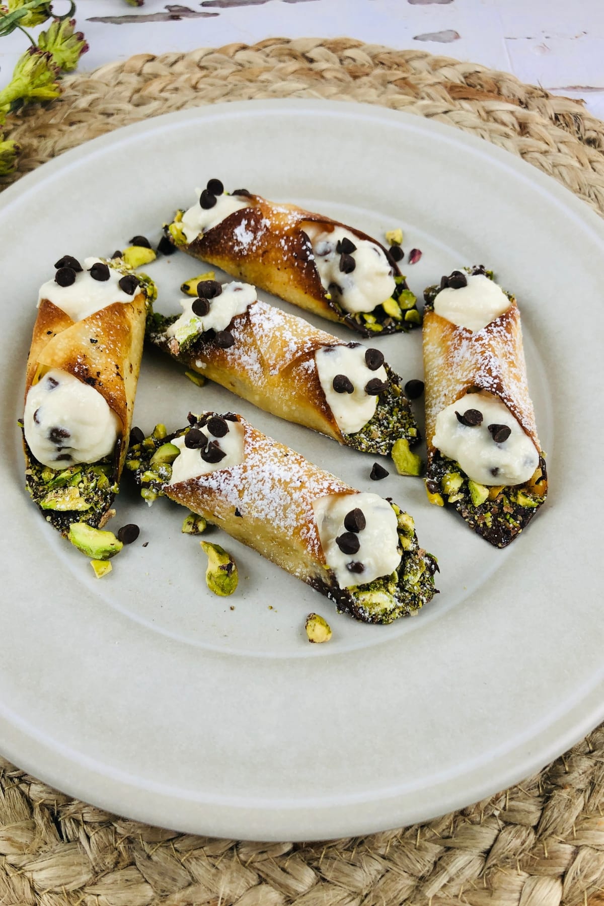 Mini cannoli topped with chocolate chips and powdered sugar.