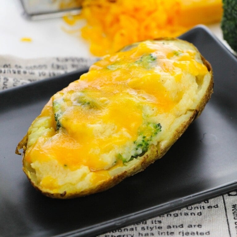 Stuffed potato with broccoli and cheese on a plate.