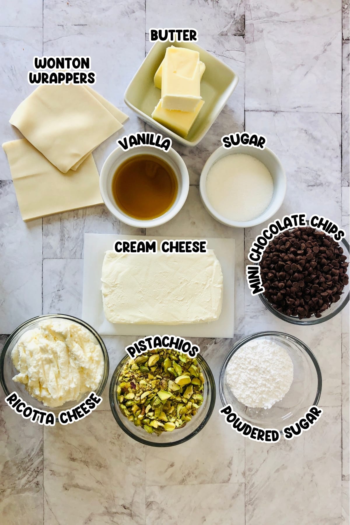 Ingredients for mini cannoli sitting on a marbled countertop.