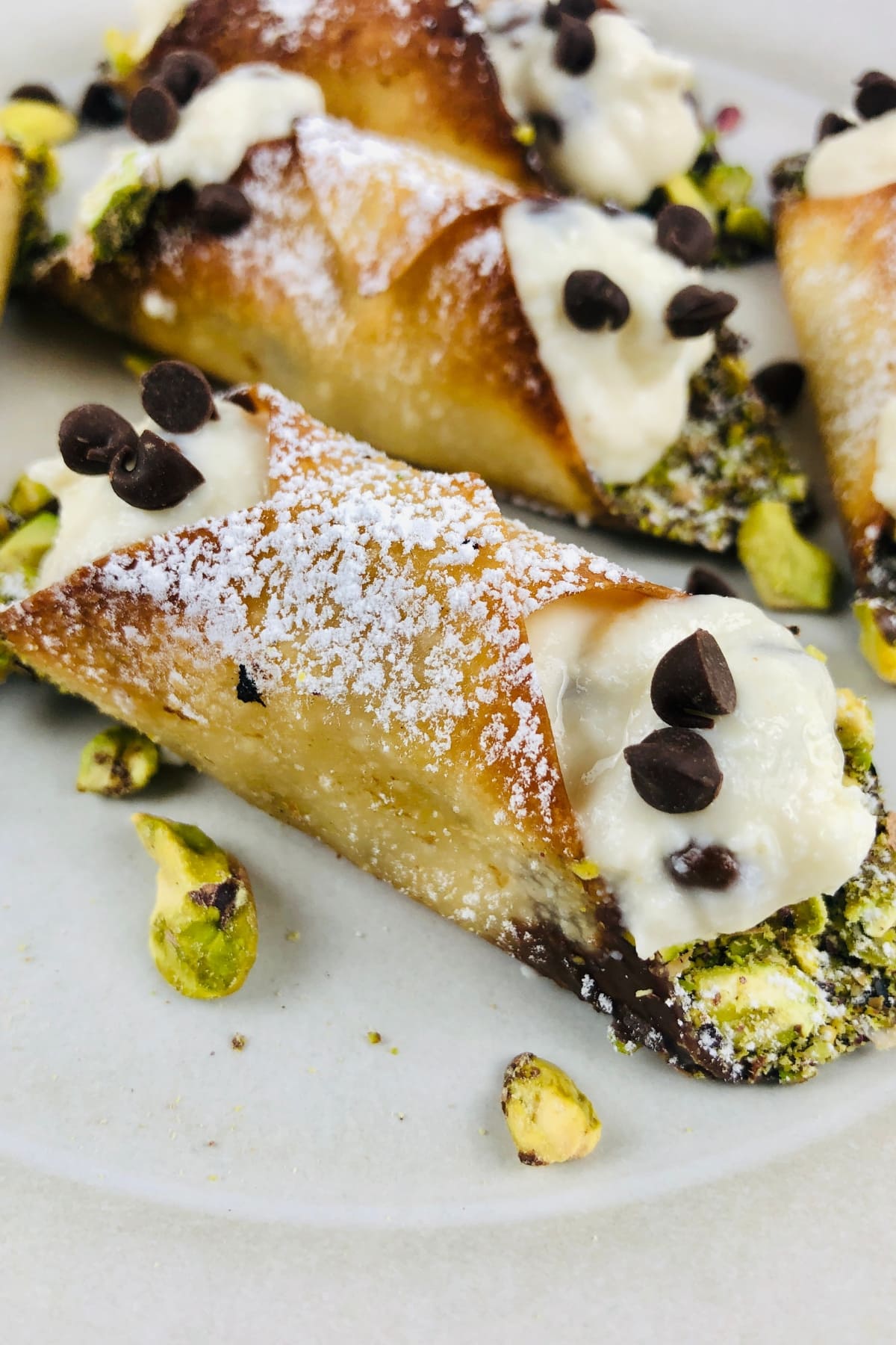 Wonton shell with cream filling topped with powdered sugar and mini chocolate chips.