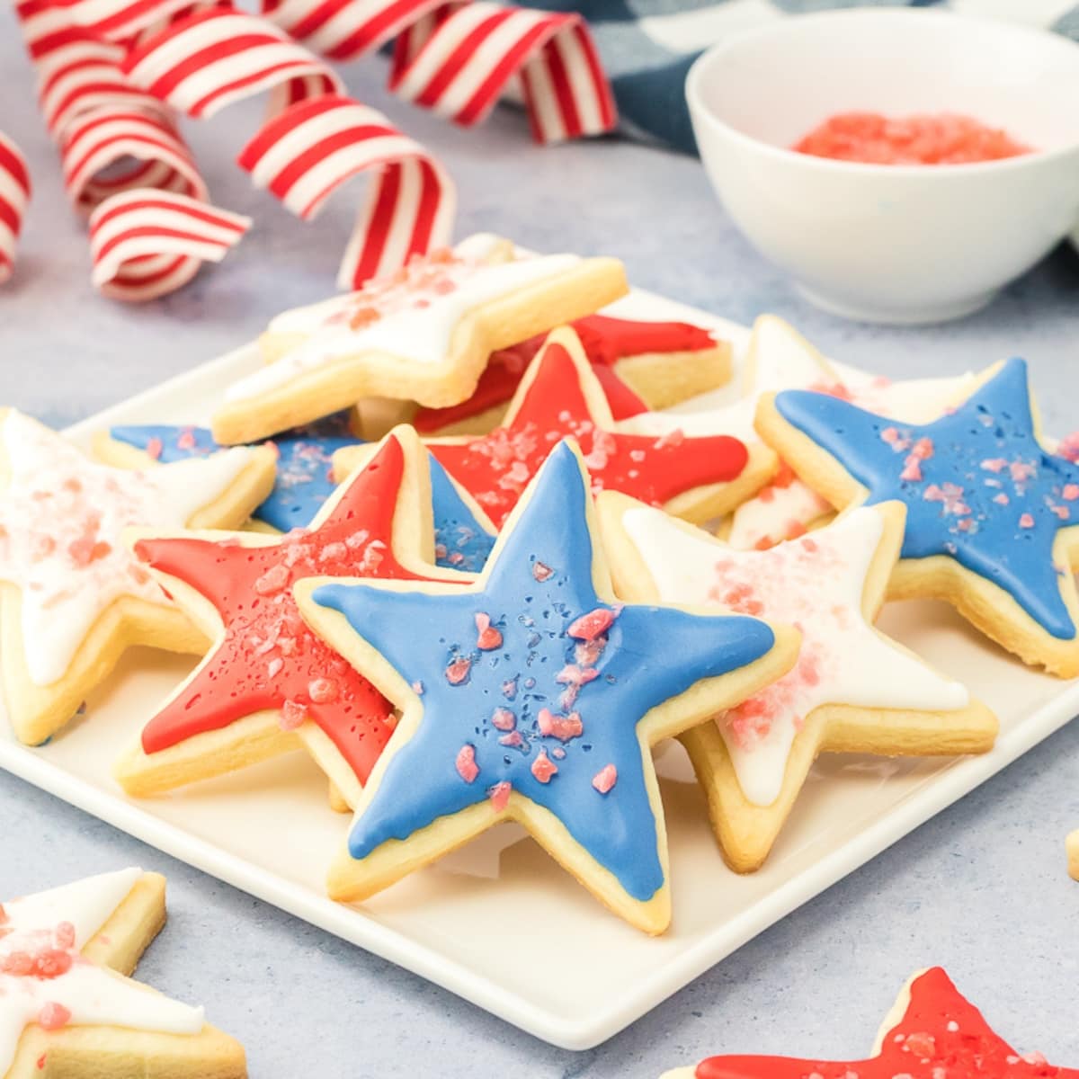 Sugar Cookies with frosting and popping candy on top on a white plate.