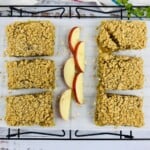 Oatmeal bars and sliced apples on parchment paper.