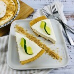 A plate with a slice of key lime pies topped with lime slices.