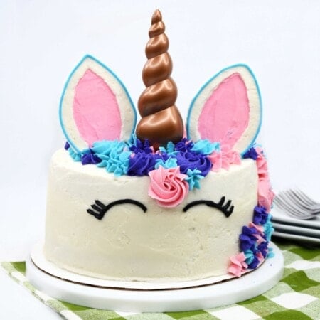 Cake with unicorn decorations on a white plate.