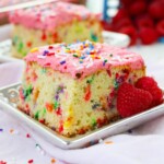 Funfetti Cake with pink frosting on a white plate.