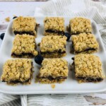 A plate of nine oatmeal bars with blueberry jam filling.