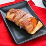 A plate of Salmon wrapped with bacon.