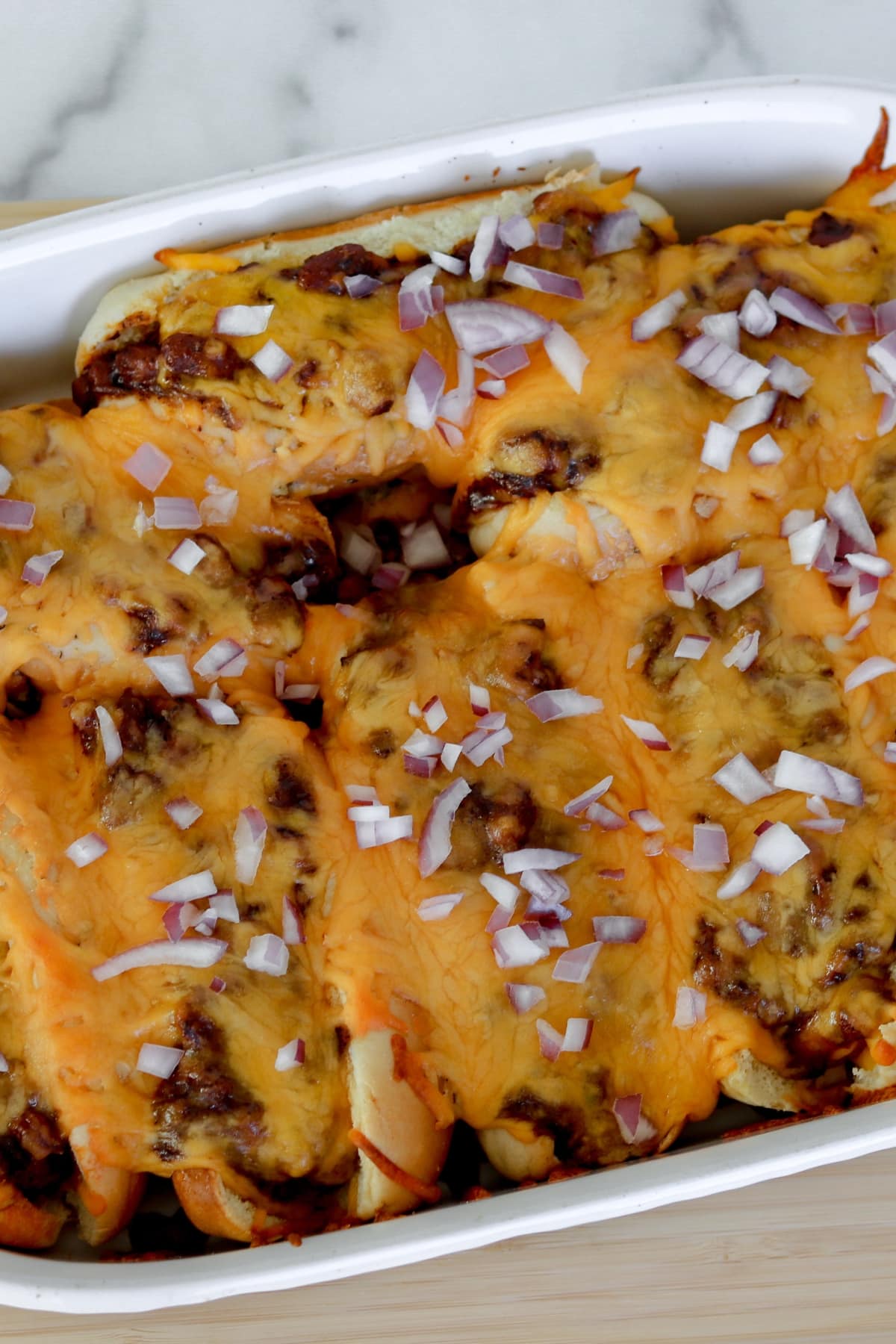 Diced onion sprinkled on a Chili Cheese Dog Bake.
